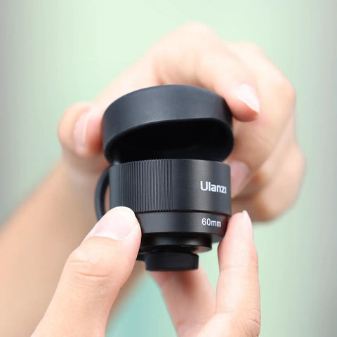 Close-up of a Phone Macro Lens With 10x Optical Magnification And 75mm Focal, 17mm Thread, being held to show detailed view.