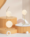 Mid Century Modern Brass Table Lamp With Gold Glass Globe on round platforms, featuring golden metal accents.