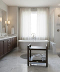 Elegant bathroom with 24 Inch Teak Shower Bench With LiftAide Arms, placed beside freestanding tub, showcasing storage shelf.