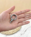 Six Pack 304 Stainless Steel M4 Eye Bolts With Matching Hex Nuts held in hand, showcasing sturdy design for rigging.