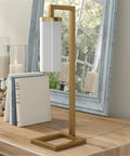 Tall Floor Lamp With Glass Milk Shade In Brass Finish, Stands At 67.75 Inches Tall, Steel Base on wooden table near mirror