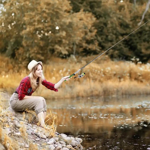 Woman fishing by river with Pen Sized 55 Inch Mini Pocket Fishing Pole Travel Rod Set For Ice Fly Sea Saltwater And Freshwater