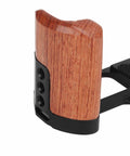 Close-up of wood handle on aluminum camera cage rig with 1/4 inch and 3/8 inch screw holes, cold shoe mount, vertical video mounts