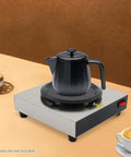 Straight Up Coffee Pot Warmer Hot Plate Keeping Daily Brews And Teas Properly Toasty With Reliable Eighty Watt Steady Heat For Kitchen Counters Or Office Desks Smooth Vibes For Kickback Gatherings And Cafes, featuring a black pot on a metal heating surface.