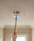 Using Heavy Duty Aluminum Alloy Smoke Sensor Disassembler Tool For Office Checks to reach a smoke detector on the ceiling.