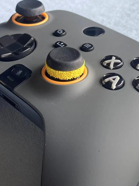 Close-up of yellow FPS Aim Assist Target Rings 8 Pack for Precise Aiming and Smooth Motion on controller joystick.