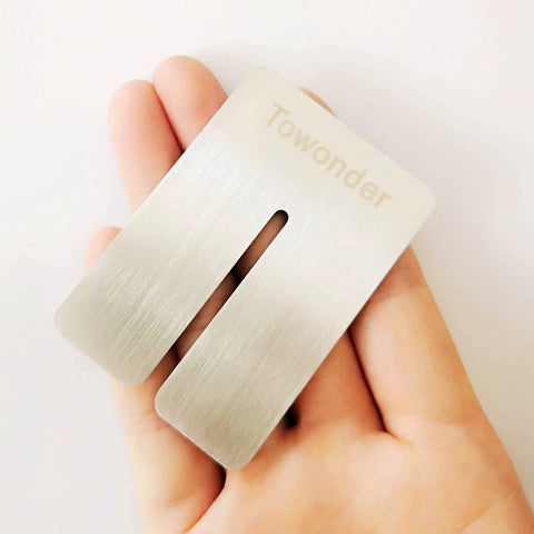 Hand holding metallic component of Punching Pad Kit For Leather Work With Yellow Cushioned Protective Mat And White Cutting Board