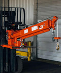 Heavy Duty Fork Mounted Jib Crane With Electric Winch Pivoting Telescopic Boom Extends To 138 Inches Wireless Remote shown on forklift.