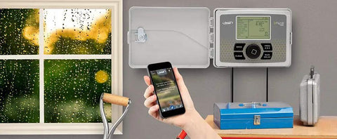 B Hyve Smart Indoor Outdoor Sprinkler Controller 6 Zone App Controlled Smart Controller shown beside window during rain