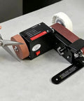 Badass Compact Desktop Electric Belt Sander Set For Sharpening Knives Metal Parts And Wood Projects With Adjustable Speed Settings and Comfortable Grip on workbench.