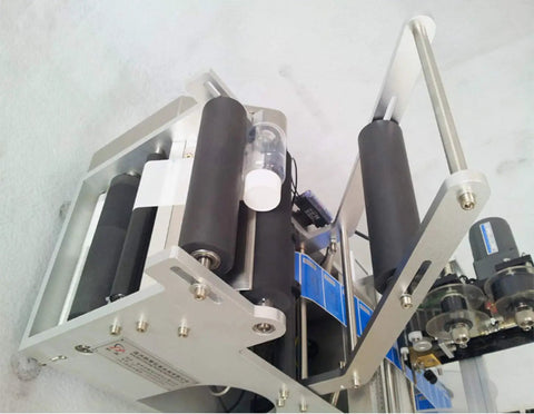 High Speed Round Bottle Labeling Machine Plus Slick Date Printer and Rock Solid Applicator showing rollers and motors, designed for heavy duty beverage containers.