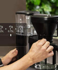 Heavy Duty Fully Automatic Espresso And Drip Coffee Maker With Digital Display adjusting settings for precise brewing.