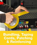 Person using Yellow Colored Duct Tape with Strong Adhesive and Water-Resistant Backing for Indoor & Outdoor Multi-Surface Use behind a TV.