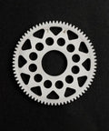 Delrin Competition Spur Gear 64P 74T for 1/10 scale touring and drift cars, white, high precision, low noise, pro grade gear on black background