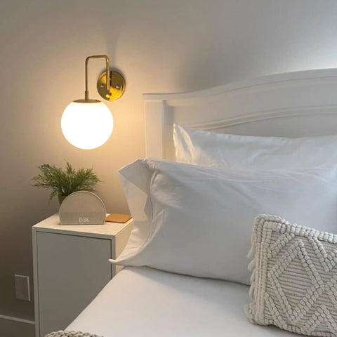 Gold Plug In Wall Sconce With Milk Glass Shade Globe Lighting Brass Swing Arm Wall Light Fixture For Hallway Bathroom Bedroom One Light On Off Switch ETL Listed Modern Minimalist Home Decor installed next to a bed