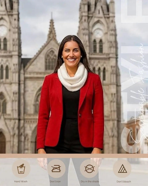 Woman wearing Ultra Cozy Winter Cashmere Infinity Scarf In Beige, standing outdoors in a red jacket, with a cathedral background.