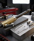 Pneumatic Die Grinder With Extended Shaft For Crevice Work Built Tough Aluminum Body, placed on workbench with tools and accessories.