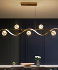 Modern Linear Pendant Light Set Featuring Six Glass Globe Shades Dimmable Gold Kitchen Island Fixture above dining table.