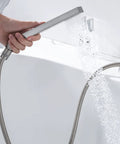 Handheld shower in use from Roman Tub Faucet Deck Mount Waterfall Three Hole with Hand Shower Brushed Nickel Modern Tub Filler Spout