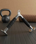 Triceps Training Bar For Cable Pulldown And Pressdown Sturdy Rubber Grip Bar on gym mat with kettlebell and foam roller background.