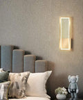 Super Tight 16W Gold LED Wall Sconce With Dimmable Rectangle Frame And Switchable Warm Natural White Glow To Honestly Level Up Your Bedroom Or Living Room Setup With Zero Fuss At All on soft gray wall beside plush bed.