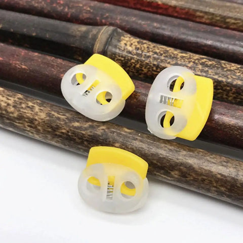 30 Pack Adjustable Button Spring Buckles Plastic Rope Locks With Toggle Fasteners Go To DIY Gear Multi Purpose Snap Joints For DIY Projects And Clothing, Fits Hoodies Sweatpants Jackets Backpacks Five Random Colors. Yellow plastic rope lock buckles shown close up