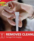 Hand demonstrating adhesive strip feature from Under Sink Sponge Caddy Set Pack of 2 With 8 Adhesive Strips, Damage-Free Organization.