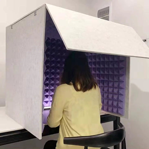 Portable Microphone Soundproof Foam Booth Cube High Density Noise Isolating Acoustic Panels For Podcast Content Creator Studio Recording Streaming Voiceover Desk Setup with user sitting inside.