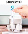 Scoring stylus being inserted into machine from Six Piece Vinyl Tool Kit For DIY Crafters With Scoring Stylus Weeder With Cap Scissors Tweezers Spatula And Scraper For Vinyl Paper And Iron On Projects.