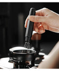 Top Shelf Telescopic WDT Tool For Espresso Distribution With 8 Bonus Stainless Steel Needles in action stirring coffee grounds.