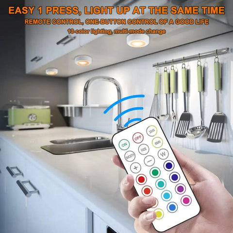 Hand holding remote for 13 Color LED Puck Lights With Remote Control Wireless Battery Powered Stick On Under Cabinet Lighting in kitchen