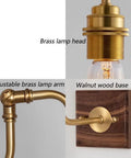 Close-up of Vintage Brass Wall Sconce showing adjustable brass lamp arm, brass lamp head, and walnut wood base.