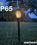 P2 Solar Flickering Flame Torch Light With Realistic Fire, IP65 Waterproof Outdoor Tiki Lamp in a garden during rain