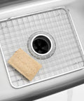 Stainless Steel Sink Grid With Center Drain Polished Finish For Kitchen Use Tough As Nails Heavy Duty Protective Rack That Prevents Scratches Doubles As A Draining Tray And Drying Rack Fits Most Standard Sinks placed in sink with sponge