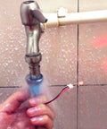Person holding a small water turbine generator under running tap water, part of a Wind Hydroelectric Generator Model For STEM Classrooms.