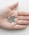 100 Pieces 3mm x 18mm Stainless Steel Dowel Pins For Shelf Support And Cabinet Fastening in a hand, rust resistant metal fasteners.