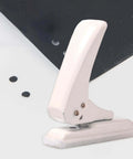 Portable Workhorse One Hole Punch Handheld Metal Hole Puncher With 40 Sheet Paper Capacity shown punching through black paper