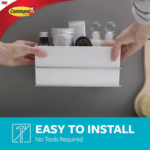 Hands installing wall and cabinet organizer with water resistant strips for clutter free bathroom, no tools needed, easy to install.