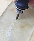 Steel Precision Replacement Tip Kit For Pneumatic Engraving Pen used for intricate design on glass surface showing fine lettering.