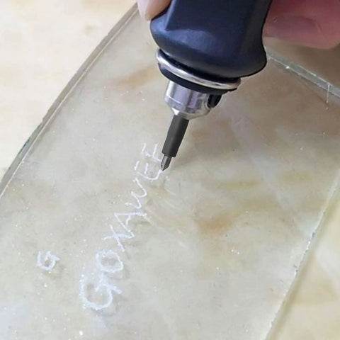 Steel Precision Replacement Tip Kit For Pneumatic Engraving Pen used for intricate design on glass surface showing fine lettering.