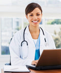 Woman in Women White Lab Coat For Medical Pros Pro Grade Long Sleeve Doctor Costume Style Button Closure using laptop