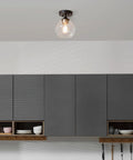 Harrow 1 Light Semi-Flush Mount Ceiling Light With Matte Black Finish, Gold Accent Socket, Clear Glass Shade, in kitchen setting