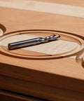 Close-up of a circle cut in wood using Circle Cutting Router Jig With Pro Grade Precision For Making Perfect Circles From Two And A Quarter Inches To Eighteen And One Sixteenth Inches In One Sixteenth Inch Increments 256 Circle Sizes Industrial Grade Polycarbonate Lifetime Guarantee, drill bit on top.