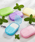 Grab and Go Disposable Soap Sheets Set, 5 Boxes of Fragrant Paper Soap in assorted colors with herbs on marble surface.