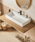 HAOCHRYSYPH Wall Mount Sink, Solid Surface, Matte White, 36 x 18 in. installed on wood countertop with black faucet.