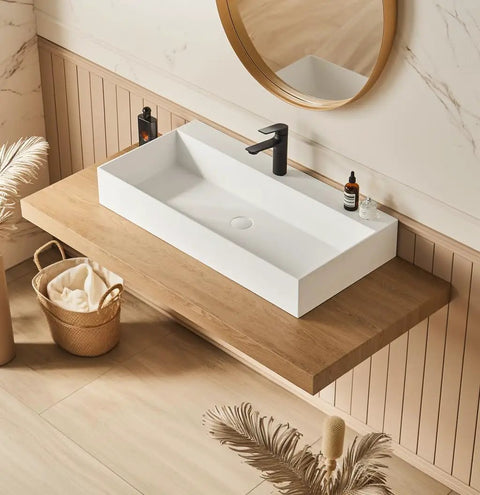 HAOCHRYSYPH Wall Mount Sink, Solid Surface, Matte White, 36 x 18 in. installed on wood countertop with black faucet.