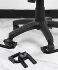 Lock And Load Your Rolling Ride With This Bulletproof 4 Pack Of Non Slip Rubber Wheel Stopper Bed Frame Caster Blocker Heavy Duty Floor Anchor Secures Office Chairs Desks Couches Tight No More Drifting Wheels, close up of black rubber wheel stoppers under a rolling chair.