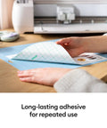 Close-up of hands using LightGrip Cutting Mat Pack 6 Pack 12x12 Inches For Lightweight Paper Cardstock And Printables Reusable Durable Mats With Long Lasting Adhesive That Wont Crack Compatible With Explore And Maker Series.