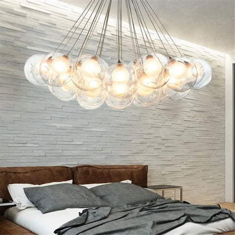 Drop Dead Stunning Modern Glass Pendant Chandelier With Polished Chrome Finish And Efficient Led G4 Bulbs hanging over a bed with decorative pillows.