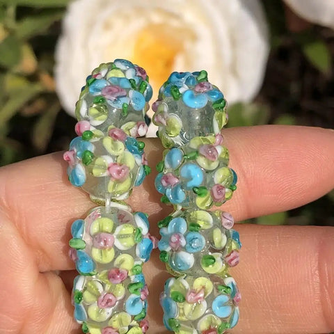 Score These Hella Rad Lampwork Glass Round Spacer Beads With Big Center Holes Perfect For DIY Jewelry Making Kicking Up Your Bracelet And Necklace Crafting Vibes Today, beaded spacer in green and blue floral patterns.